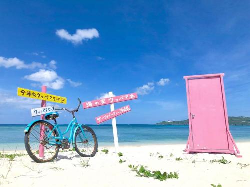 a bike parked on a beach with street signs at KIN Seaside Hills Town in Igei