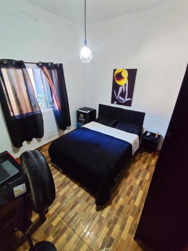 a bedroom with a bed with a blue bedspread at Casa no lago de Javary in Miguel Pereira
