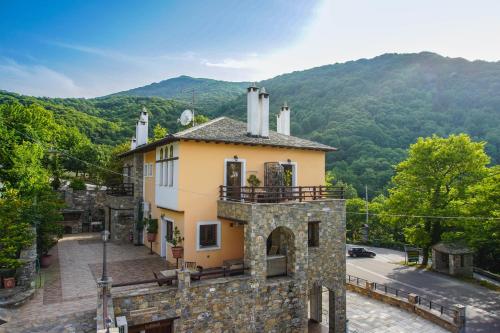 a stone building with a balcony on top of it at Nikolaou House in Tsagarada
