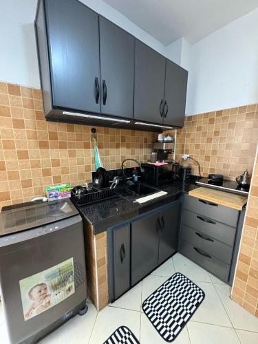 a kitchen with black cabinets and a counter top at alojamiento en tanger bab Andaluz 3 in Tangier