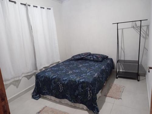 a bedroom with a bed with a blue blanket at Recanto Eucaliptos in Araçoiaba da Serra