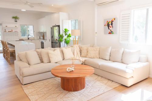 a living room with a white couch and a table at Beautiful Queenslander Getaway in Brisbane