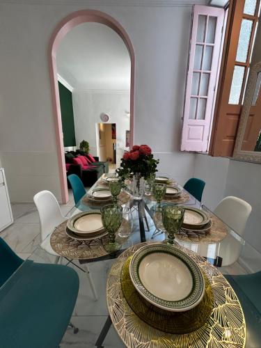 a dining room with a table with plates and flowers at Casarão para 16 pessoas in Rio de Janeiro