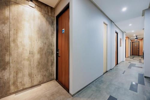 a corridor of a hallway with wooden doors and tile floors at RedDoorz Plus near Radio Dalam 3 in Jakarta