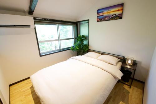a bedroom with a white bed and a window at Amesoko 747 in Amesoko