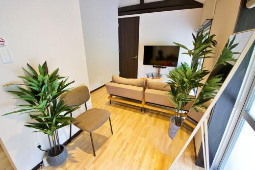 a living room with a couch and two potted plants at Amesoko 747 in Amesoko