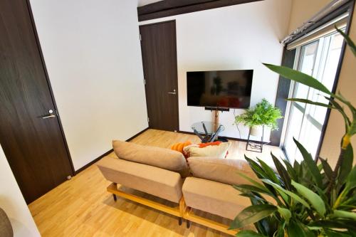 a living room with a couch and a flat screen tv at Amesoko 747 in Amesoko
