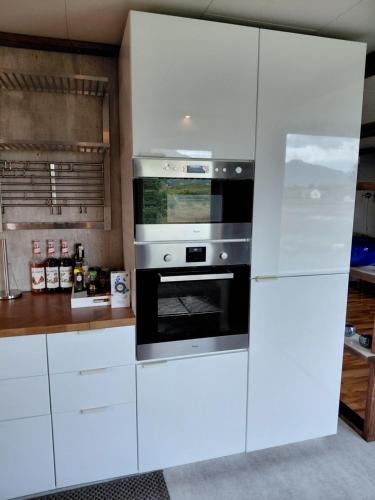 a kitchen with white cabinets and an oven at Fredvang - 5 bedrooms Feriehus - Lofoten in Fredvang