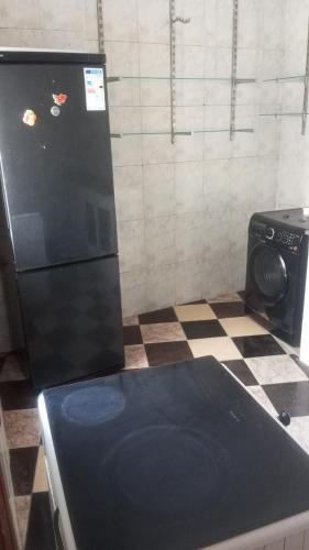 a kitchen with a black refrigerator and a tiled floor at Tetouan Tetúan تطوان in Tetouan