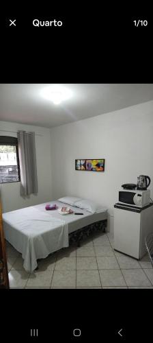 - une chambre avec un lit et une cuisinière dans l'établissement Quarto com banheiro casa da Mari, à Maringá