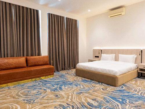 a hotel room with a bed and a couch at Central Square Hotel in Baku