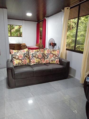 a brown couch in a room with windows at Casa La Montaña in Sámara