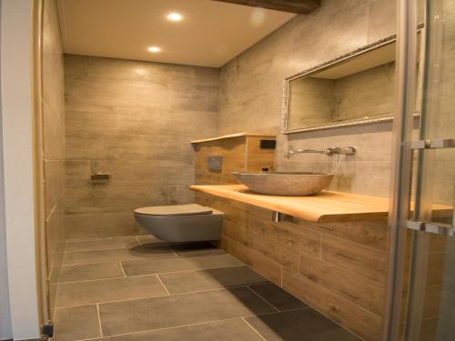 a bathroom with a sink and a toilet at Modern 4-person bungalow near beach in Petten
