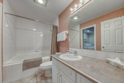 a bathroom with a sink and a toilet and a tub at Cozy Fairmont Hot Springs 1br Condo in Fairmont Hot Springs