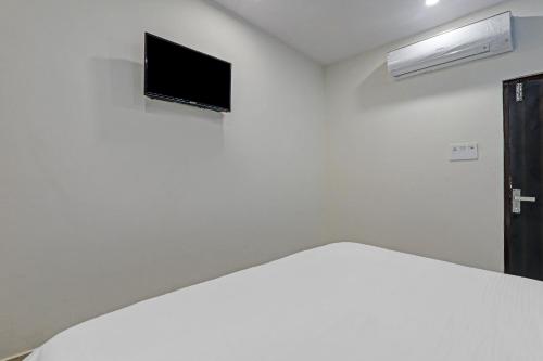 a room with a tv on a white wall at Hotel O Rudra Palace Near Phoenix United Lucknow in Charbagh