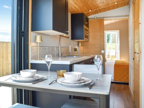 a kitchen with a table with plates and wine glasses at Sky Lark Lodge - Uk49904 in Appley Bridge