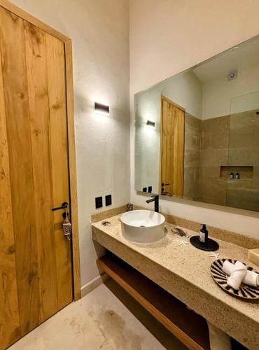 a bathroom with a sink and a large mirror at ÚNICO LA PUNTA HOTEL BOUTIQUE Beach club in Brisas de Zicatela