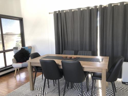 a dining room with a wooden table and chairs at Motel Maclean in Maclean