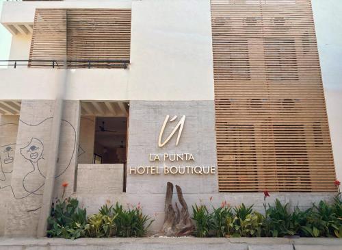 a hotel building with a sign on the side of it at ÚNICO LA PUNTA HOTEL BOUTIQUE Beach club in Brisas de Zicatela