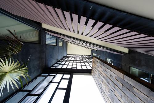an empty hallway of a building with windows and a plant at Apartment with Private Jacuzzi, Rooftop Pools & Free beach club in Tulum
