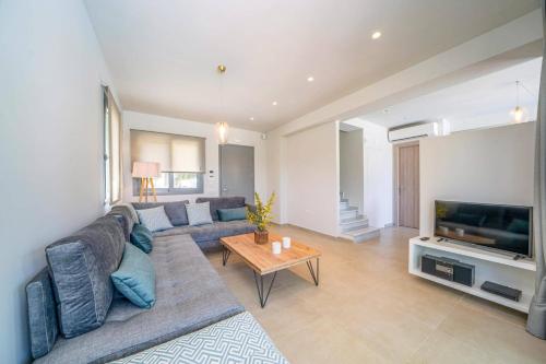 a living room with a couch and a television at Villa Mandolin by Villa Plus in Sami