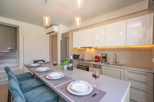 a kitchen with a table with glasses of wine at Villa Mandolin by Villa Plus in Sami
