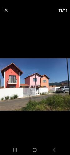 a picture of a house with a car in front of it at Chalé 4 vista para montanha in Penedo