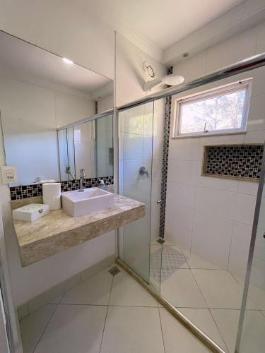 a bathroom with a sink and a shower at Quarto-Suíte Serra Petrópolis in Petrópolis
