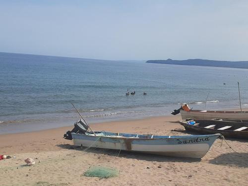 two boats on the beach with people in the water at Le Petit Oasis a few steps from the Beach in Peñita de Jaltemba