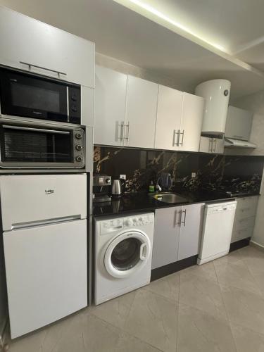 a kitchen with a microwave and a washing machine at appart plage in M'diq