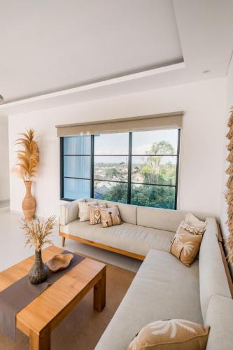 a living room with a couch and a table at Villa Three & Three in Nusa Dua
