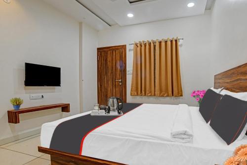 a bedroom with a large bed and a television at FabHotel Adiyogi Aura in Indore