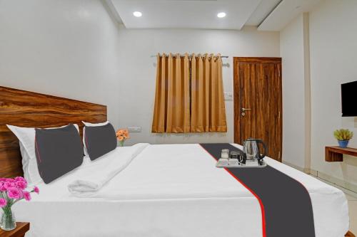 a bedroom with a large white bed and a television at FabHotel Adiyogi Aura in Indore