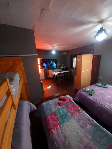 a room with two beds and a dining room at Hospedaje Tidae in Tinogasta
