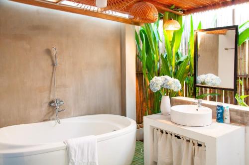 a bathroom with a bath tub and a sink at Mer Bleue Homestay Phòng Family in Ke Ga