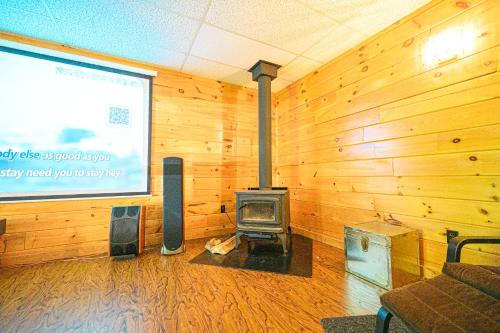 a living room with a wood paneled wall with a fireplace at Lodge at Madawaska Ideal for Groups and hiking in Lake Saint Peter