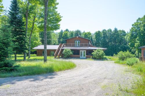 a house with a dirt road in front of it at Lodge at Madawaska Ideal for Groups and hiking in Lake Saint Peter