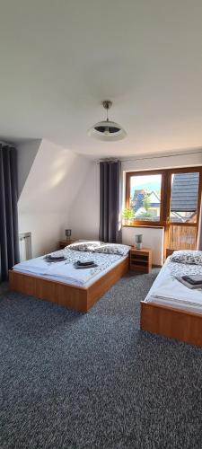two large beds in a large room with a window at Willa Ewelinka in Zakopane