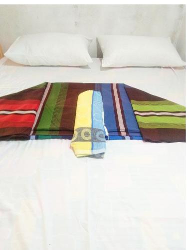 a bed with a colorful comforter on it at Fr Resort in Arugam Bay