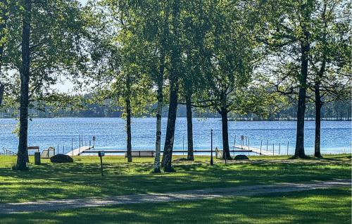 a park with trees and a dock in front of the water at Nice Apartment In Landeryd With Wifi in Långaryd