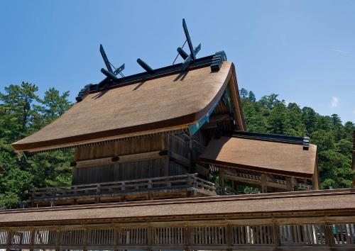 a building with a roof with two wind turbines on it at 一棟貸しゲストハウス マリドール in Izumo