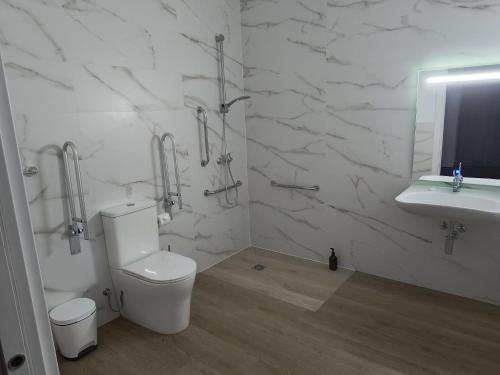 a white bathroom with a toilet and a sink at Paradise Suites Madrid in Madrid
