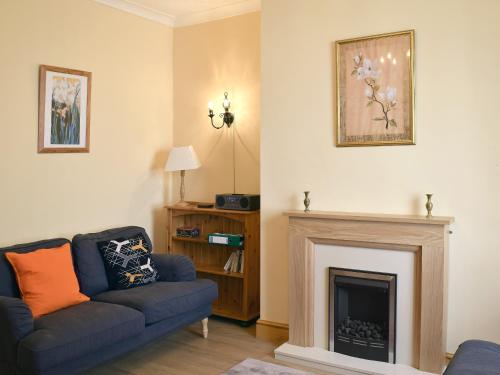 a living room with a couch and a fireplace at Gable Cottage in Keswick