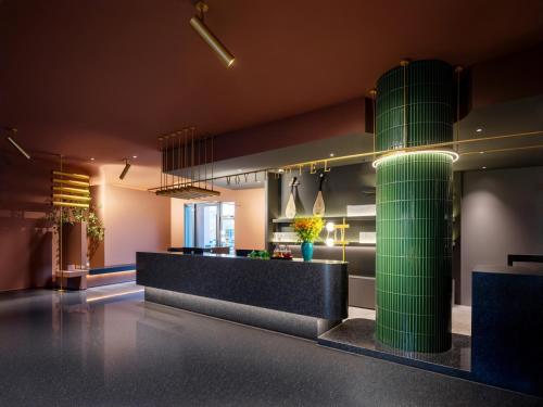 a lobby with a green column in the middle of a room at Suzhou Shantang Street Night Mooring Hotel in Suzhou