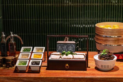 a table topped with different types of food and dishes at Suzhou Shantang Street Night Mooring Hotel in Suzhou