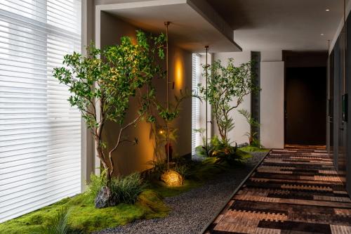 a corridor with trees and plants in a building at Suzhou Shantang Street Night Mooring Hotel in Suzhou