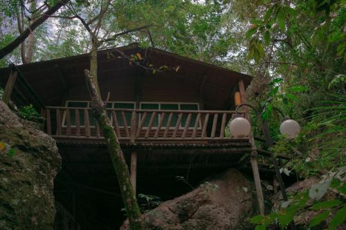 a cabin in the woods with a deck at Eco Hotel El Reposo in Melgar