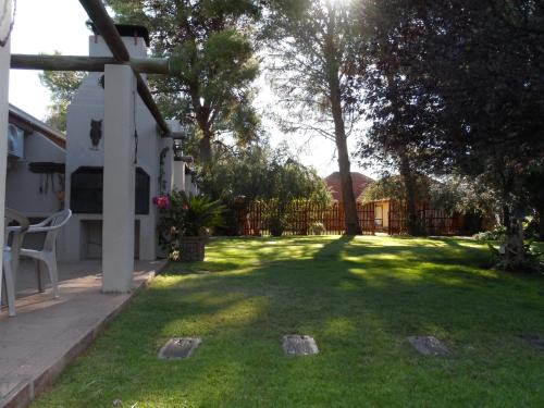 a yard with a fence and a grassy yard with a tree at A Cherry Lane Self Catering and B&B in Bloemfontein