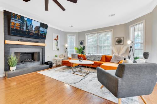 a living room with an orange couch and a fireplace at Eva's Zen House Downtown ATL Retreat in Atlanta