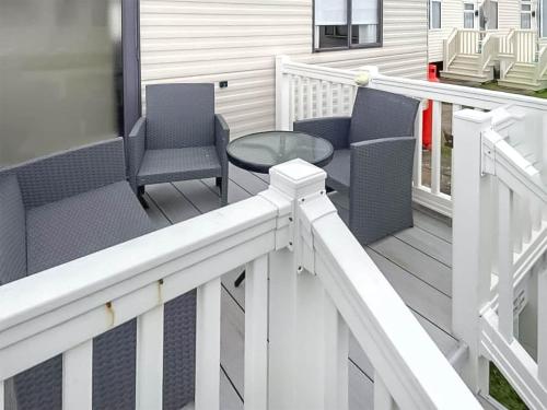 a porch with chairs and a table on a house at Merse Place 57- Uk46905 in Mainsriddle